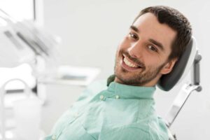 A dental professional examining a patient's teeth in a bright, modern dental office.